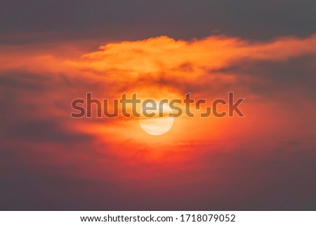 Beautiful big sun set in the middle of the cloud,Isolated huge sun at twilight,Magical moment at the sky,Giant orange sun set red sky and cloud move silhouette.Open view background.-Image