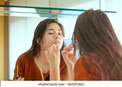 Beautiful Biracial Asian Caucasian Teen Girl Putting Makeup On While Looking In Mirror