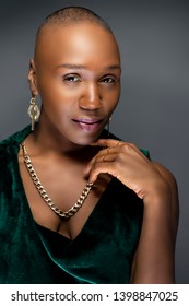 Beautiful Black African American Female Model Posing Confidently With Bald Hairstyle In A Studio.  The Woman Is Wearing Stylish Fashion And Portraying Uniqueness And Individuality.  