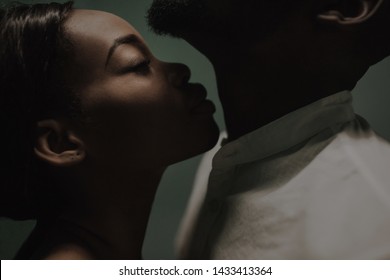 beautiful black couple closing to a kiss. girl smelling man's neck. kiss in the neck. fine art portrait of black lovers. smelling concept. love concept. perfumes smelling concept. aroma  