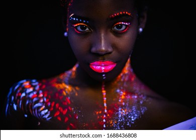 beautiful black girl with creative fluorescent prints on skin, on body. cosmic art on body. neon lights, ultra-violet rays, luminescence concept