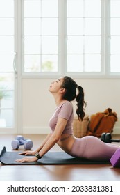 Beautiful Black Haired Asian Woman Wearing Sportswear Exercise Indoor At Home While Watching Video Tutorial On Tablet. Online Workout Training. Sport, Fitness And Healthy Lifestyle Concept.