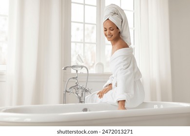 Beautiful Black lady sitting on bathtub, preparing relaxation bath in the morning, touching water in tub indoors and woman enjoying domestic spa time - Powered by Shutterstock