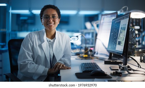 Beautiful Black Latin Woman Wearing Glasses Smiling Charmingly Looking at Camera. Young Intelligent Female Scientist Working in Laboratory. Technological Laboratory in Bokeh Blue as Background - Shutterstock ID 1976932970