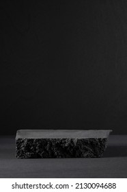 Beautiful black stand or podium, scene with black stone and black background. Black background with place for the product. Dark background 
