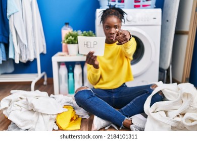 Beautiful Black Woman Doing Laundry Asking For Help Pointing With Finger To The Camera And To You, Confident Gesture Looking Serious 