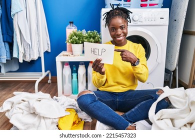 Beautiful Black Woman Doing Laundry Asking For Help Smiling Happy Pointing With Hand And Finger 