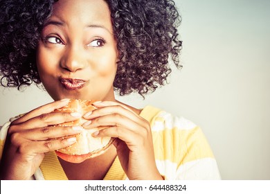Beautiful black woman eating hamburger