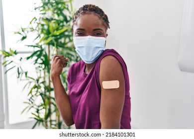 Beautiful Black Woman Getting Vaccine Showing Arm With Band Aid Screaming Proud, Celebrating Victory And Success Very Excited With Raised Arms 