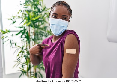 Beautiful Black Woman Getting Vaccine Showing Arm With Band Aid Pointing Finger To One Self Smiling Happy And Proud 