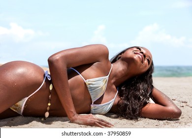 Beautiful black woman lying on the beach