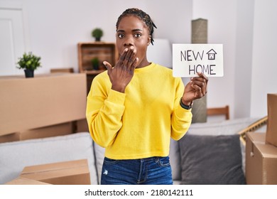 Beautiful Black Woman Moving To A New Home Covering Mouth With Hand, Shocked And Afraid For Mistake. Surprised Expression 