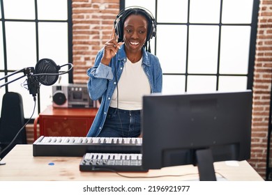 Beautiful Black Woman Playing Piano At Music Studio Smiling With An Idea Or Question Pointing Finger With Happy Face, Number One 