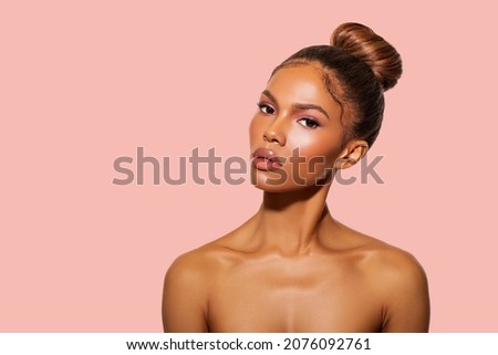 Beautiful Black Woman posing in studio on peach background. Fashion Portrait Black Woman in white stylish linen dress. Makeup, curly Hair.                                          