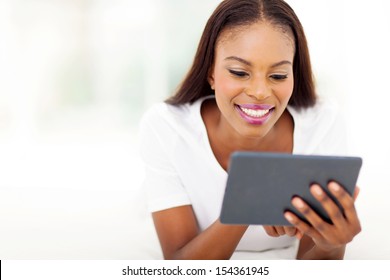 Beautiful Black Woman Using Tablet Computer On Bed