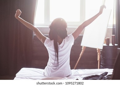 Beautiful Black Woman Waking Up In Her Bed, She Is Smiling And Stretching.