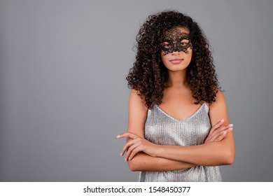 beautiful black woman wearing elegant masquerade mask isolated over grey - Powered by Shutterstock