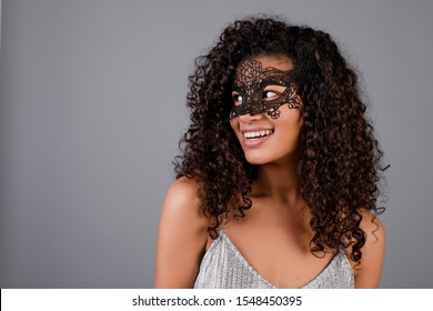 beautiful black woman wearing elegant masquerade mask isolated over grey - Powered by Shutterstock