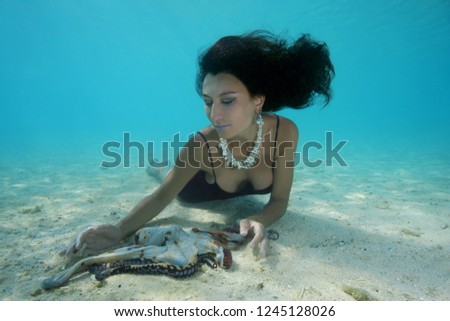 Beautiful black-haired woman in dress with Big Blue Octopus (Octopus cyanea) in Indian Ocean, Maldives