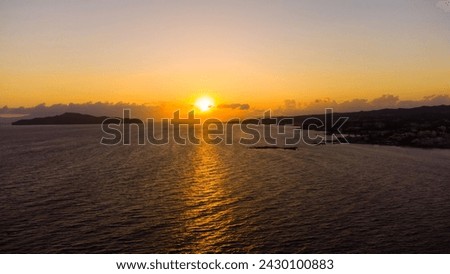 Beautiful blazing sunset landscape at black sea and orange sky above it with awesome sun golden reflection on calm waves as a background. Amazing summer sunset view on the beach