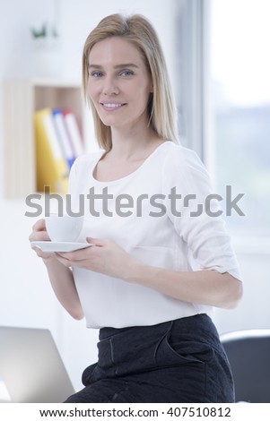Beautiful Blond Businesswoman in Office with Coffee