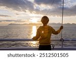 Beautiful blond child with yellow sweater, enjoying ferry ride between Bodo and Lofoten Moskenesoya summertime, child on a ferry on sunset