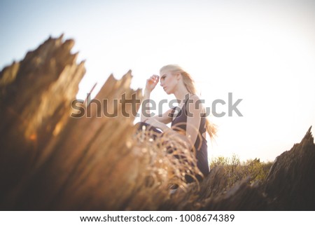 Beautiful blond female model standing on a mountain enjoying the view
