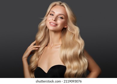 Beautiful blond girl with a perfectly curls hair, and classic make-up. Beauty face and hair.