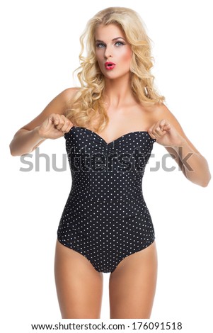 Beautiful blond girl pulling up her polka dots swimsuit