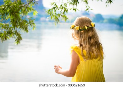 Beautiful Blond Girl In Yellow Dress With Flower Headband By The River Strand Back View