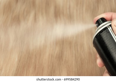 Beautiful blond hair across the entire screen. Hand holds a spraying spray for fixing and shaping. - Powered by Shutterstock