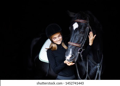 Beautiful Blond Professional Female Jockey Standing Near Horse. Woman Horse Rider Is Preparing To Equitation. Girl And Horse. Equestrian Sport Concept. Riding Horse Vacation