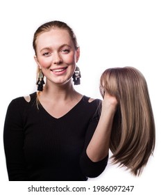 A Beautiful Blond White Woman, Smiling, Holding The Blond Wig, Isolated On The White Background 