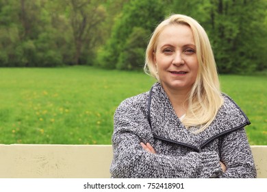 Beautiful Blond Woman 45 Years Old In City Park.