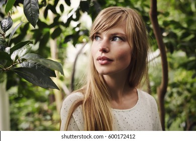 Beautiful blond woman with blue eyes in garden - Powered by Shutterstock