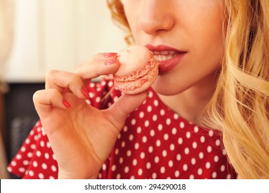 Beautiful Blond Woman Eating Macaroon. Shot In The Cafe