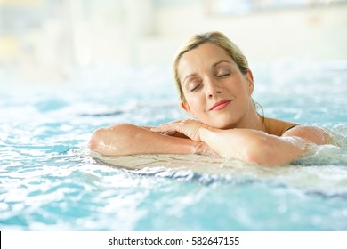 Beautiful blond woman relaxing in thalassotherapy thermal water