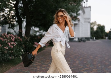 Beautiful blond woman  in stylish fashion casual outfit posing  on the street.  Warm sunset color. 