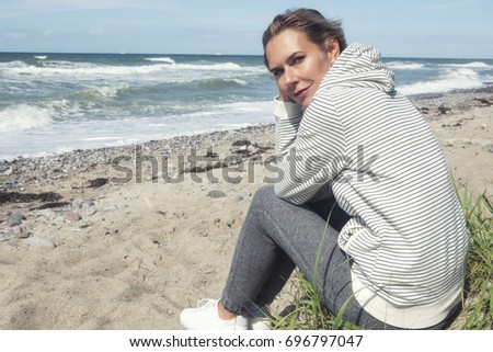 Similar – Woman walking on a beach on a cloudy day