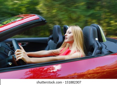Beautiful Blond Young Woman Driving A Sports Car