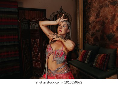 beautiful blonde belly dancer girl with pink bedlah outfit and henna mehndi on her arm
