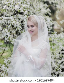Beautiful blonde bride in wedding dress. Female portrait in the park. Woman with hairstyle. Cute lady outdoors
