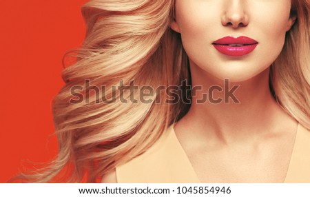 Beautiful blonde colorful woman portrait with perfect hairstyle beauty face red lips and flower in hair summer trendy colors