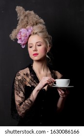 Beautiful blonde countess with a cup of tea on dark background - Shutterstock ID 1630086166