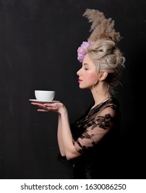 Beautiful blonde countess with a cup of tea on dark background - Shutterstock ID 1630086250