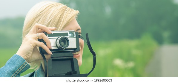 Beautiful Blonde Female Photojournalist Traveling And Taking Picture Outdoors. Copy Space For Text Or Design.