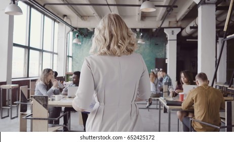 Beautiful Blonde Female Team Leader Walk Through The Office, Controls The Work Of Employee, Gives Direction To Colleague