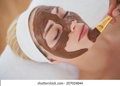 Beautiful blonde getting a chocolate facial treatment at the health spa
