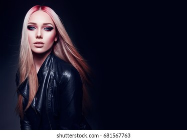 Beautiful blonde girl in black leather jacket and pink hair in rock style on black background.Makeup, cosmetics, hair care, hair dye, pink color. Fashion clothes. Fashion, beauty, rock, style, gothic.