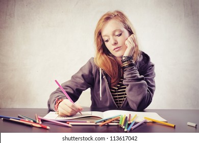Beautiful blonde girl doing her homework
